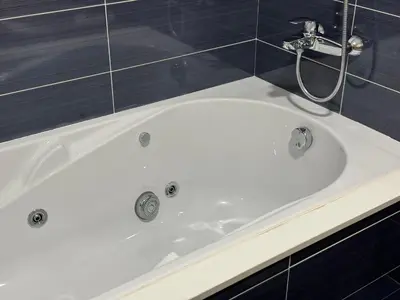 a white bath tub in a bathroom with blue tiles at Maison Liberdade By Oktheway in Sarria