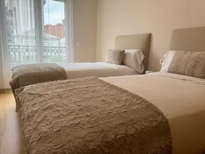 two beds in a hotel room with a window at Maison Liberdade By Oktheway in Sarria