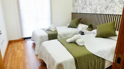 a room with three beds with white and green at Atalaia Apartment Foz in Foz