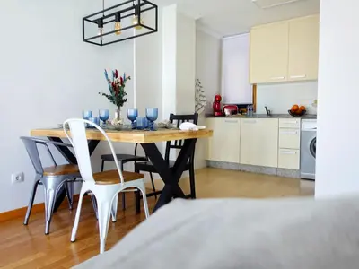 a kitchen and dining room with a table and chairs at Atalaia Apartment Foz in Foz