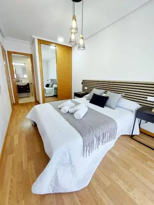 a bedroom with a large white bed with towels on it at Atalaia Apartment Foz in Foz
