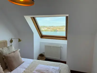 a bedroom with a window with a view of the water at O Faiado Da Ria By Oktheway in Culleredo