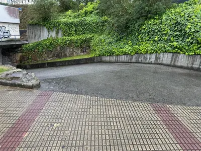 an empty parking lot next to a stone wall at O Faiado Da Ria By Oktheway in Culleredo