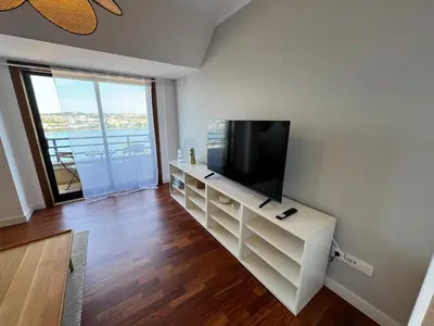 a living room with a flat screen tv on a white cabinet at O Faiado Da Ria By Oktheway in Culleredo