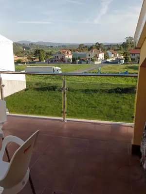 a balcony with a view of a green field at Rincón de Noa in Melide