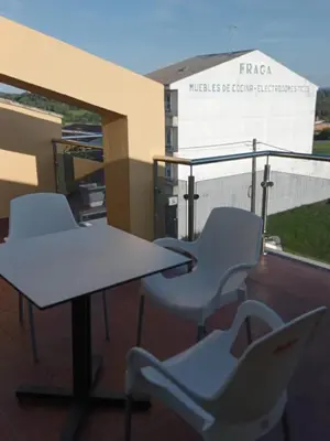 two chairs and a table on a balcony at Rincón de Noa in Melide