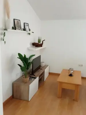 a living room with a tv and a table at Rincón de Noa in Melide