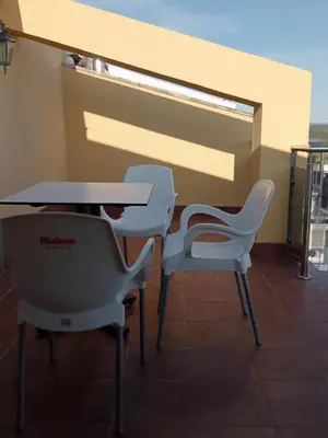 two white chairs and a table and a table and chairs at Rincón de Noa in Melide