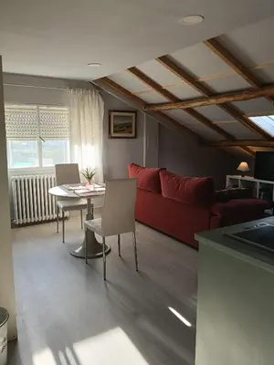 a living room with a red couch and a table at Apartamento Riazón3 in Ourense