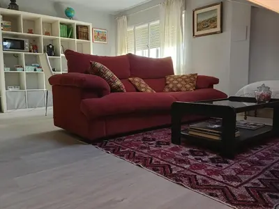 a red couch in a living room with a table at Apartamento Riazón3 in Ourense
