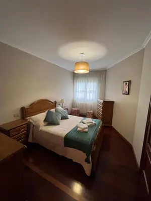 a bedroom with a bed with a green blanket at O Carballal in A Pontenova