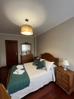 a bedroom with a bed and a lamp and a mirror at O Carballal in A Pontenova