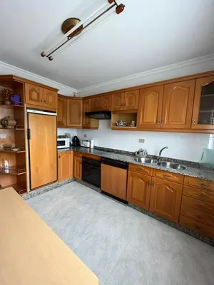 an empty kitchen with wooden cabinets and a sink at O Carballal in A Pontenova