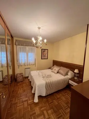 a bedroom with a bed and a chandelier at Tres Ruas in A Pontenova