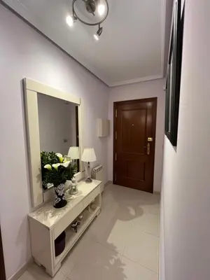 a bathroom with a mirror and a table with a vase of flowers at Tres Ruas in A Pontenova