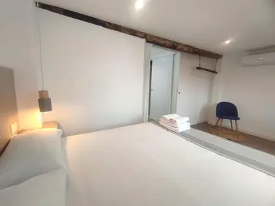 a bedroom with a white bed and a blue chair at Lepanto 4 - Precioso y súper luminoso dúplex con vistas in Ourense