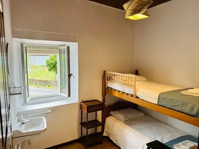 a bedroom with two bunk beds and a sink and a window at Casa Cerdeira Ribeira Sacra in Monforte de Lemos