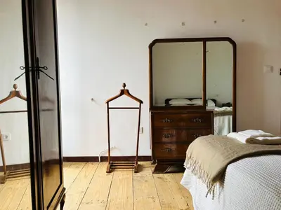 a bedroom with a mirror and a dresser and a bed at Casa Cerdeira Ribeira Sacra in Monforte de Lemos
