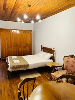 a bedroom with a bed and a chair and a table at Casa Cerdeira Ribeira Sacra in Monforte de Lemos