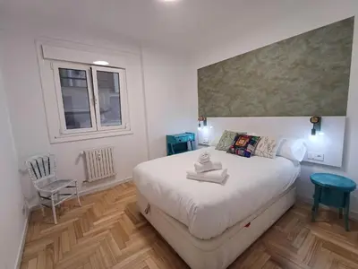 a bedroom with a large white bed and a window at La glorieta del Miño in Ourense