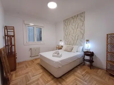 a bedroom with a large white bed and a window at La glorieta del Miño in Ourense