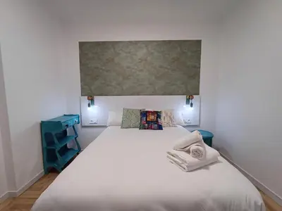 a bedroom with a large white bed and blue shelves at La glorieta del Miño in Ourense