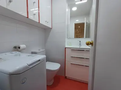 a white bathroom with a toilet and a sink at La glorieta del Miño in Ourense
