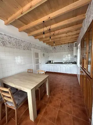 a large kitchen with a wooden table and chairs at El polvorín in El Franco