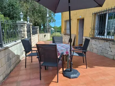 a table with chairs and an umbrella on a patio at El polvorín in El Franco
