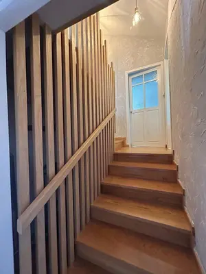 a hallway with stairs with a white door at El polvorín in El Franco