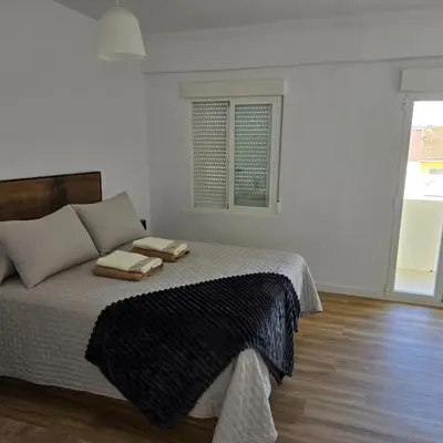 a bedroom with a bed with two towels on it at piso libertad in Ourense
