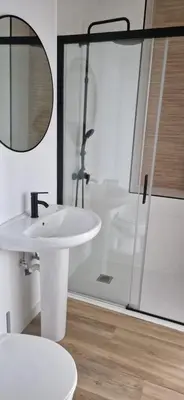 a white bathroom with a sink and a shower at piso libertad in Ourense