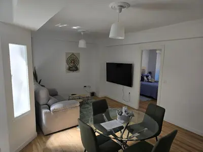 a living room with a table and chairs and a television at piso libertad in Ourense