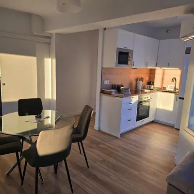a kitchen and dining room with a glass table and chairs at piso libertad in Ourense