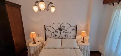 a bedroom with a bed with two lamps on two tables at El Mirador de Covas - 2 Hab - Garaje in Covas