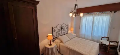 a bedroom with a bed and a table with a lamp at El Mirador de Covas - 2 Hab - Garaje in Covas