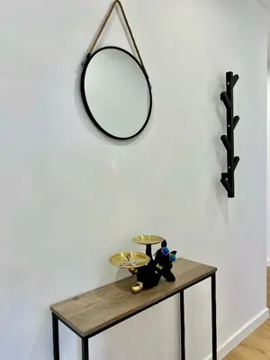 a table with a mirror on a white wall at A Casa Riquiña in Lugo