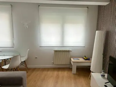 a living room with a table and a window at A Casa Riquiña in Lugo