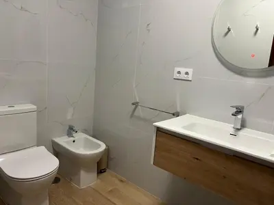 a bathroom with a toilet and a sink and a mirror at Abaleen apartamento in Sigüeiro