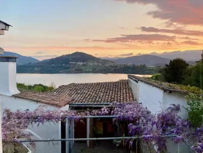 a house with a view of a lake and purple flowers at Forxa, Ventosela in Ventosela