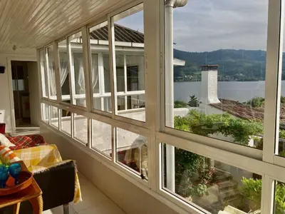 a room with large windows looking out at the water at Forxa, Ventosela in Ventosela