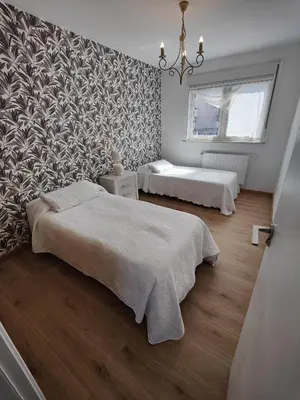 a bedroom with two beds and a patterned wall at Chalet con WIFI , PS4 , garaje, 5 dormitorios, 3 baños, Santiago de Compostela in Santiago de Compostela