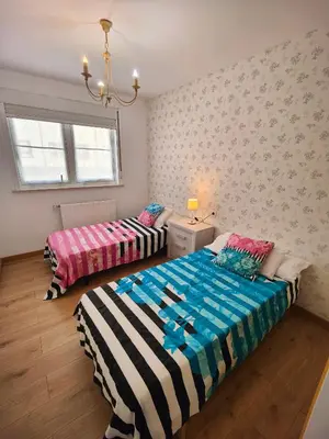 a bedroom with two beds and a window at Chalet con WIFI , PS4 , garaje, 5 dormitorios, 3 baños, Santiago de Compostela in Santiago de Compostela