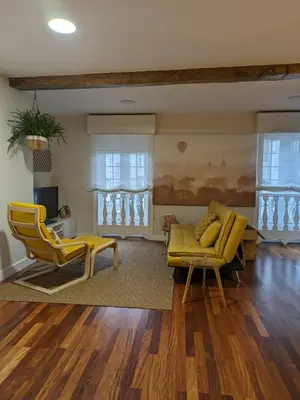 a living room with a yellow couch and chairs at La Mimosa in Puentedeume