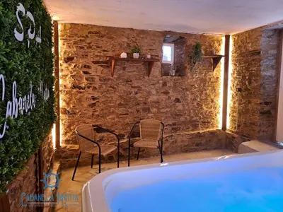 a bath tub with chairs and a table in a room at Cabanela Maitia Jacuzzi privado y barbacoa in Ribadeo