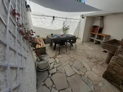 a patio with a table and chairs and an umbrella at Cabanela Maitia Jacuzzi privado y barbacoa in Ribadeo