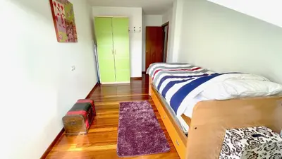 a bedroom with a bed and a wooden floor at The Cliffs - ViveMare in Viveiro