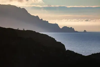 a group of people standing on a hill near the ocean at The Cliffs - ViveMare in Viveiro