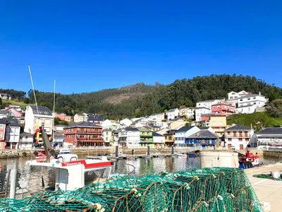 a boat is docked in a harbor with a town at The Cliffs - ViveMare in Viveiro