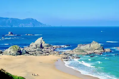 a group of people on a beach near the ocean at The Cliffs - ViveMare in Viveiro